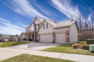 Humble abode two story home with three car garage sits on lot that needs landscaping or greenery