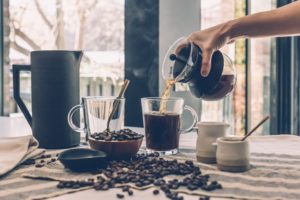 Home sells fast offer coffee to guests at the open house carafe pouring coffee into glass mug coffee beans on counter