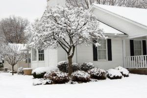 Winter cracks can happen to a home vinyl siding in winter house surrounded by snow
