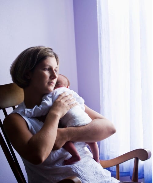 mom-looking-out-of-the-window-with-baby