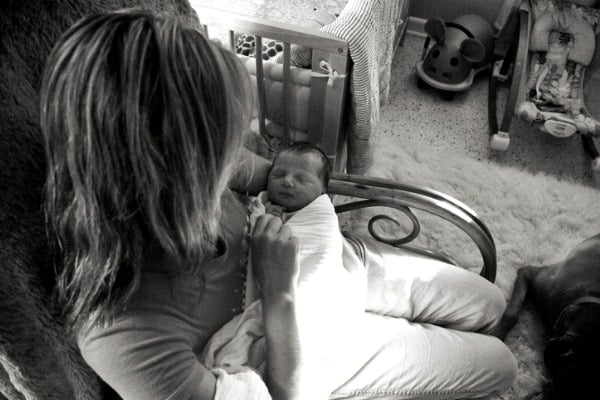 woman-holding-newborn-in-rocking-chair