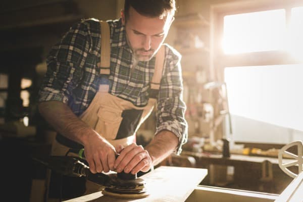 man polishing using a mechanical sander
