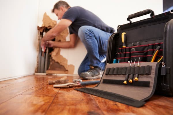 man-repairing-burst-pipe-plumbing