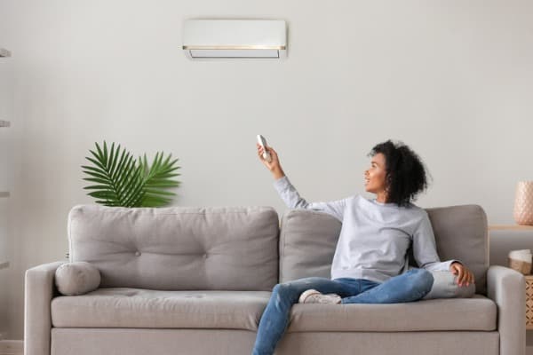 smiling-american-woman-using-air-conditioner