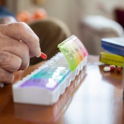 close-up-of-senior-man-organizing-medication-into-pill