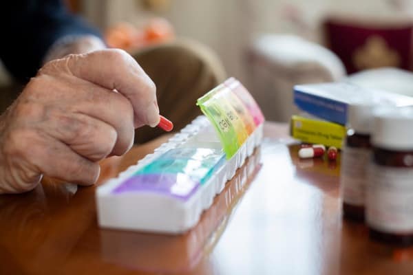close-up-of-senior-man-organizing-medication-into-pill