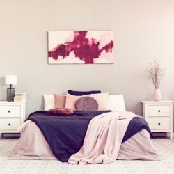 king-size-bed-with-pillows-and-blanket-between-two-wooden-nightstand