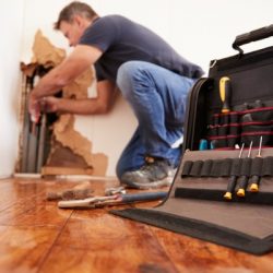 middle aged man repairing burst pipeplumbing focus on foreground