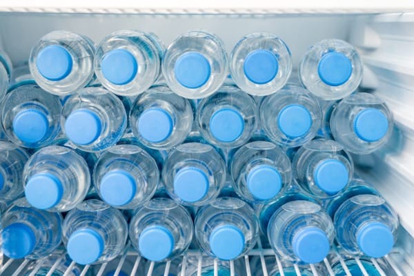 rows of many transparent plastic bottles with drinking water supply