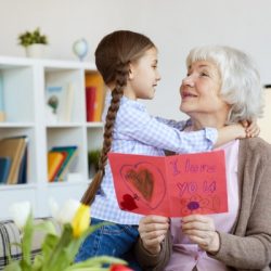 senior-woman-embracing-cute-girl