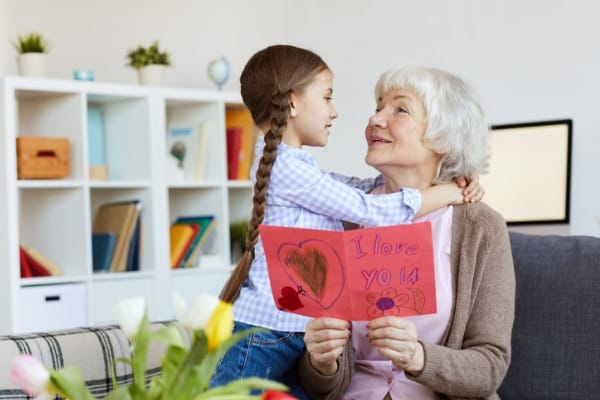 senior-woman-embracing-cute-girl