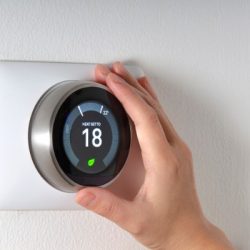 smart-thermostat-with-a-hand-saving-energy-picture-id1184491029