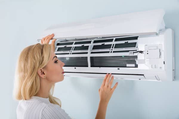 young-woman-checking-air-conditioner