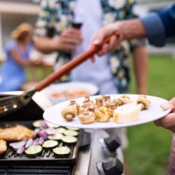 midsection of family outdoors on garden barbecue grilling