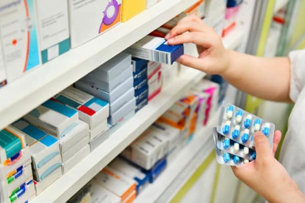 pharmacist holding medicine box and capsule pack picture id878852718
