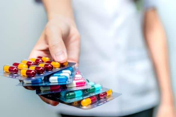 pharmacist or doctor hand holding pack of antibiotic capsule pills