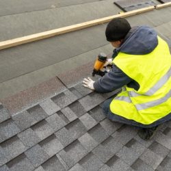 qualified workman in uniform work wear using air or pneumatic nail