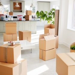 stacked removal boxes in empty room on moving day