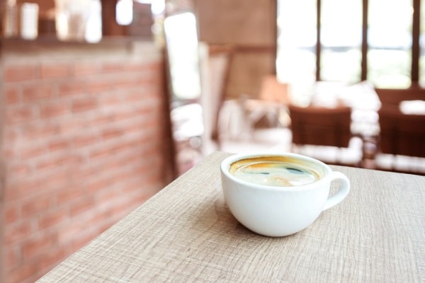 coffee cup on wood table in cafe with blur cafe