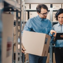 female inventory manager shows digital tablet information to a worker