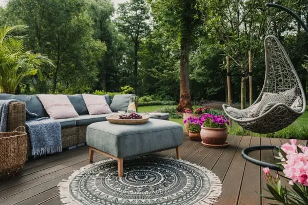 garden patio decorated with scandinavian wicker sofa and coffee table