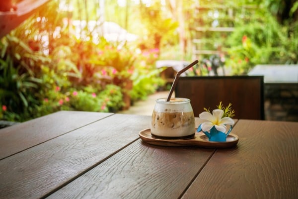 latte ice coffee serve on wooden plate decorated with white flowers