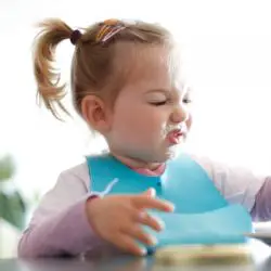 little girl toddler picking her food making faces