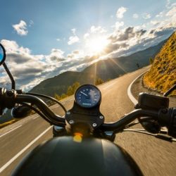motorcycle driver riding in alpine highway handlebars