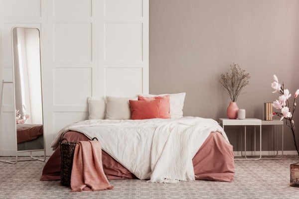 orange pillows on white king size bed in fashionable female bedroom