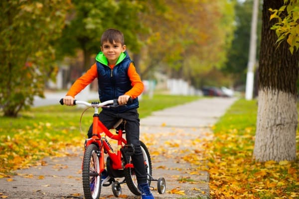 sunny autumn day boy on a bike in a city park relaxation