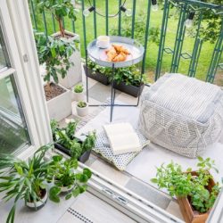 top view of a balcony with plants pouf a table with breakfast