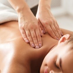 young woman enjoying therapeutic neck massage in spa