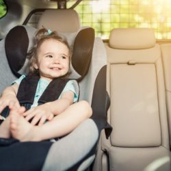infant baby girl buckled into her car seat