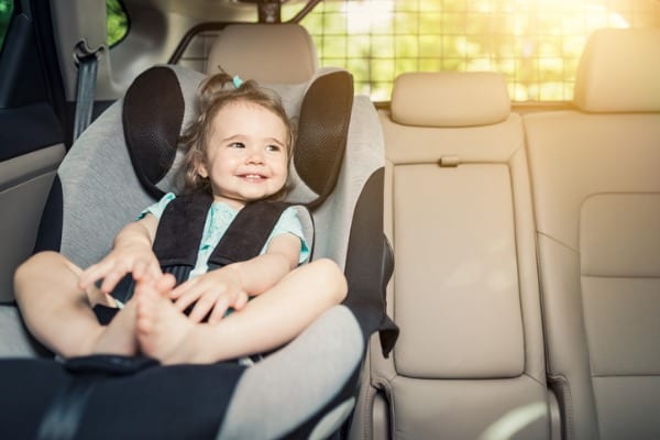 infant baby girl buckled into her car seat