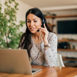 portrait of a cute woman with headset and laptop at home