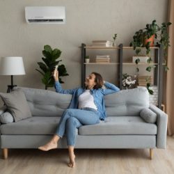 young woman relax on couch turn on ac