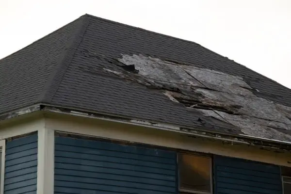 damaged and old roofing shingles and gutter system